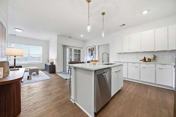 A modern kitchen with white cabinets and a wooden island.